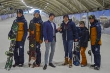 Foto: In het midden Remko Klein, Commercieel Directeur SnowWorld en Martijn van der Ploeg, Head of Overland & Wintersport bij TUI. Samen met een aantal snowboardleraren proosten zij in de sneeuwhal in Zoetermeer op de samenwerking.